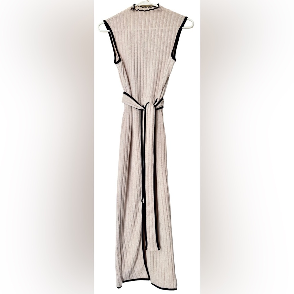 Mid-length cream colored knitted dress with wrap-around belt.